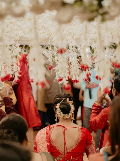 A beautiful shot from behind, showing the bride's intricate floral bun and the stunning decor.