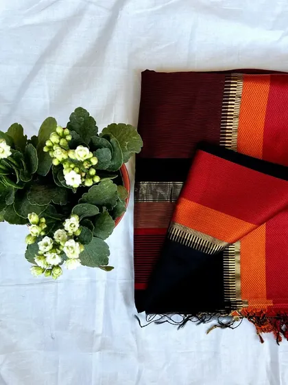 A striking Maheshwari saree with a black body and a multi-colored pallu in shades of red and orange.