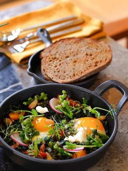 Our Green Shakshuka is a house favorite. We bake organic eggs in a vibrant mix of green vegetables and herbs, served in a cast-iron skillet with a side of toasted sourdough for dipping.