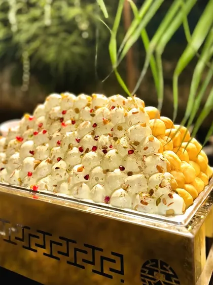 A close up of my Kesariya Dahi Bhalla counter. The bhallas are soaked in creamy, saffron infused yogurt and garnished with pomegranate seeds, offering a rich and royal version of the classic chaat.