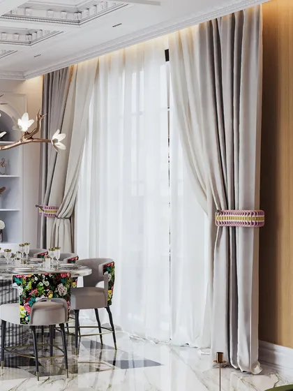 This shot focuses on the dining area, with its bold floral chairs and a sculptural, branch-like chandelier.