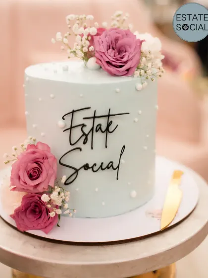 Another angle of the "Estate Social" event cake, highlighting the fresh flowers and delicate pearl details.