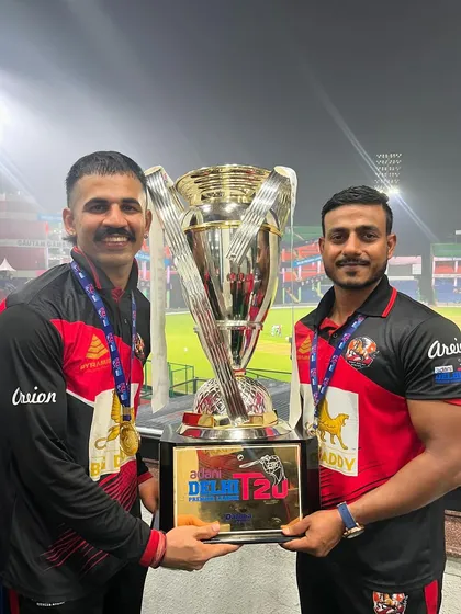 Two members of the coaching staff holding the championship trophy. A team effort in every sense of the word.