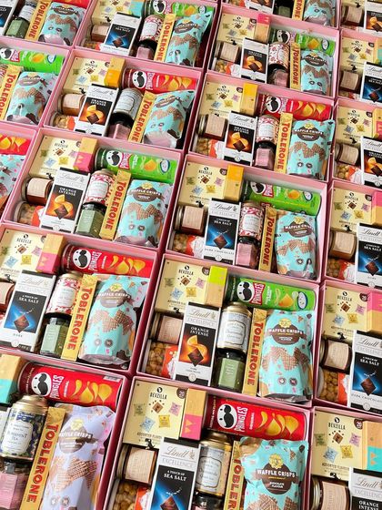 This flat-lay shot showcases the sheer variety and volume of products we can source for large return favor orders. We curated over a dozen different branded items, from Lindt and Toblerone to Pringles and Doritos, to create these packed gift boxes.