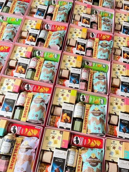 A rainbow of treats! These return favor boxes are packed with a huge variety of goodies, from Lindt and Toblerone chocolates to waffle crisps, protein bars, and instant coffee cubes.