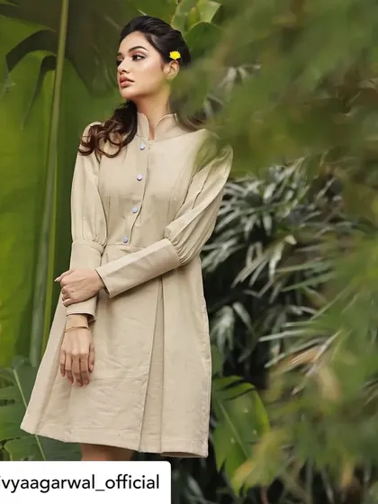 A full-length view of Divya Agarwal in our beige structured tunic dress. This shot highlights the tailored fit and the unique puff sleeves, demonstrating a perfect blend of comfort and style.