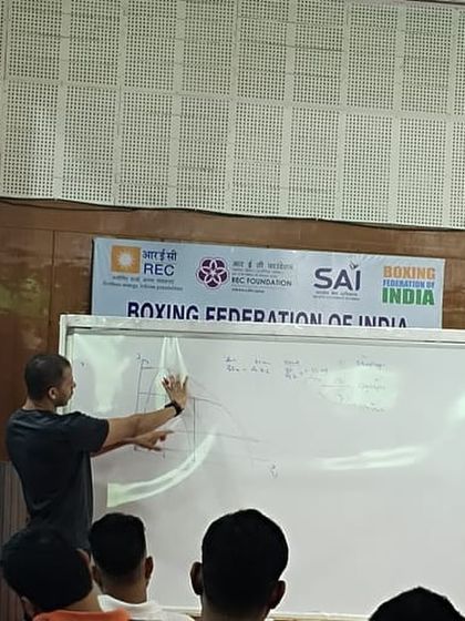 Using a whiteboard to illustrate the force-velocity curve. I break down complex biomechanical concepts into simple diagrams to help coaches understand the science behind power development.