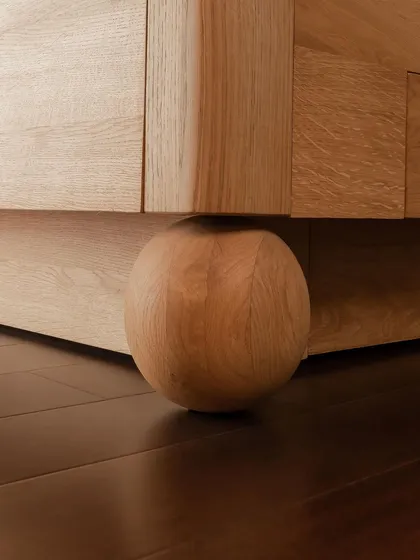 Even the feet of a piece of furniture deserve careful consideration. This solid wood spherical foot provides a strong yet gentle foundation for a cabinet, a small detail that adds immense character and a sense of grounding to the design.