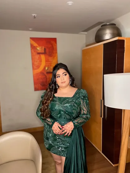 A glam goddess in this green sequin ensemble. This look is all about confidence, with a bold eye, glowing skin, and voluminous curls. Perfect for a night of celebration.