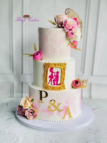 I love telling a love story through cake. This stunning three-tier engagement cake features a romantic proposal silhouette inside a golden frame, delicate stencil work, and beautiful florals, capturing the magic of a "yes" moment.