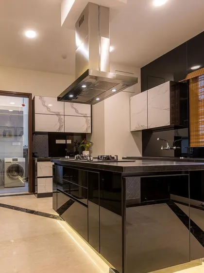 This is where culinary magic happens. I design modular kitchens that are not just beautiful but also highly functional, like this stunning island kitchen with a high-gloss black finish, marble accents, and smart lighting for a truly premium cooking experience.