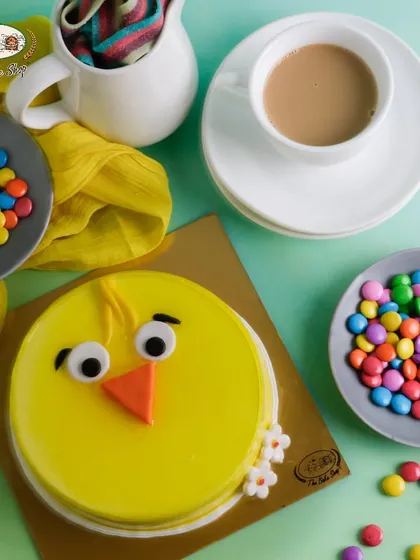 A top-down view of our adorable Pineapple Chick Cake for Easter, surrounded by colorful candies.
