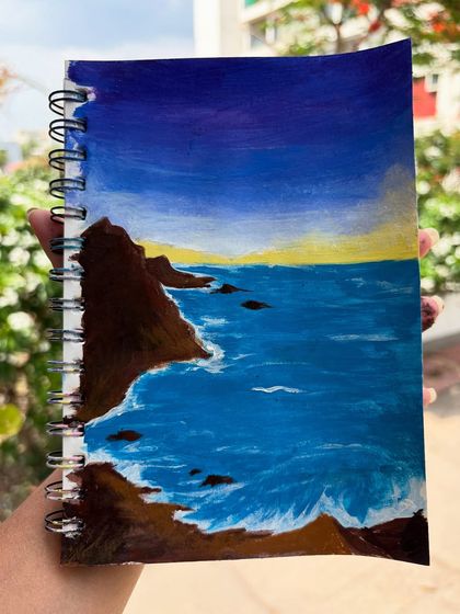A painting of a rocky coastline at dusk, created in my sketchbook as inspiration for summer art.