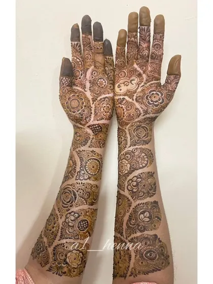 A full view of a semi-bridal henna design, showing how the pattern extends from the palms up the arms. This style is perfect for engagements or other pre-wedding events.