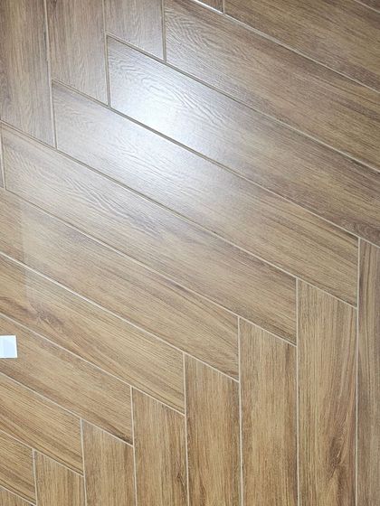 A classic oak-colored, wood-look tile in a herringbone pattern. It provides the warmth and timeless appeal of a parquet floor with the ease of maintenance of tile.