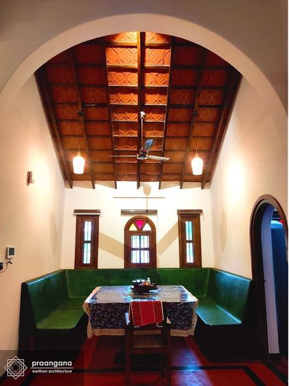 A symmetrical view of the dining space in the Udupi house. The design, with its built-in seating and central window, creates a sense of balance and harmony.