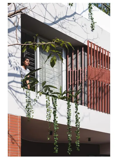 A resident enjoys the view from the balcony, demonstrating how our designs create comfortable, shaded outdoor spaces for everyday living.