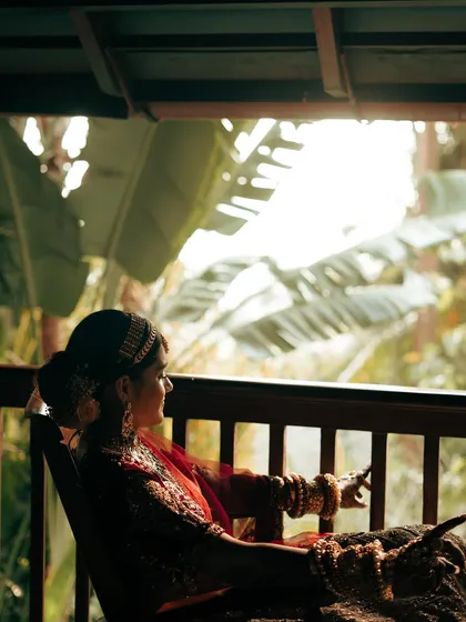 The bride looking out from a balcony, surrounded by the lush greenery of the destination. A beautiful, contemplative shot.