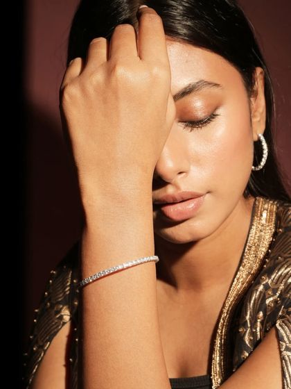 A classic diamond tennis bracelet, worn by a model. This timeless piece is a staple in any fine jewellery collection and can be customized to your exact specifications.