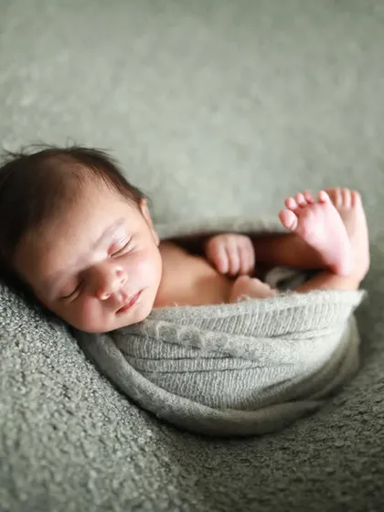 A perfect little bundle. This pose, often called the "potato sack," is a safe and adorable way to capture how tiny your newborn is.