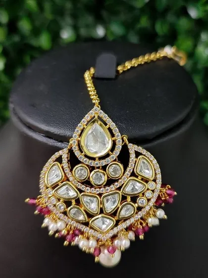 A similar design with red bead drops, this kundan maang tikka is perfect for a traditional red lehenga.