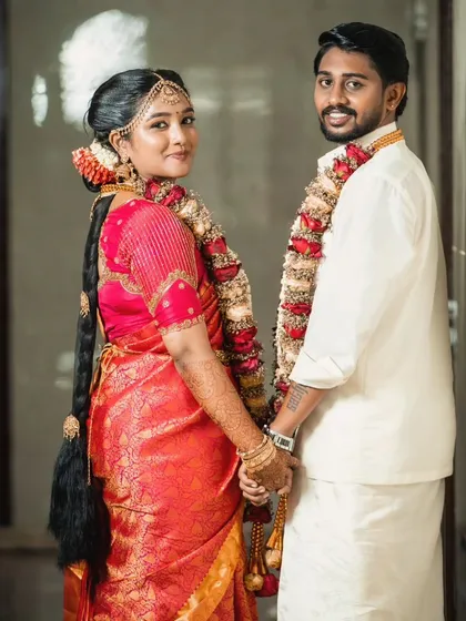 A fun, candid moment between the couple. The bride's traditional braid and makeup look perfect as she shares a laugh with her groom.