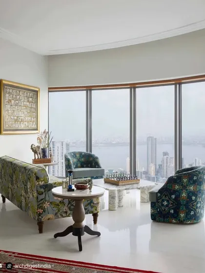 For this Mumbai high-rise residence, the living room was designed to frame the magnificent sea view. I used a mix of custom-upholstered furniture in rich patterns and a large-scale Pichwai painting to create a space that is sophisticated, comfortable, and deeply connected to its surroundings.