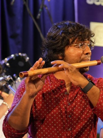 A close-up of Vidwan Shri Durgaprasad guiding his students through the performance with his own playing.