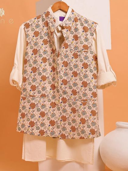 A beautiful floral jacket paired with a simple white kurta. This ensemble is perfect for a summer wedding or a garden party, offering a vibrant and stylish look.