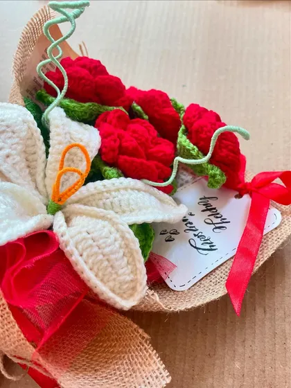 A close-up of a red and white anniversary bouquet, showing the "Happy Anniversary" tag. It's the little details that make a gift special.