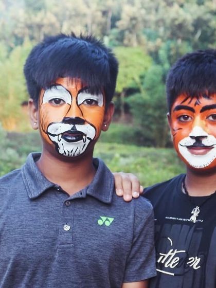 Two friends show off their matching tiger face paint at the Barapole nature awareness camp.