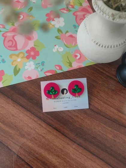 A collection of my simple and elegant fabric studs. Each pair is hand-painted with a small leaf motif and comes in a variety of colors like green, white, yellow, blue, and pink.