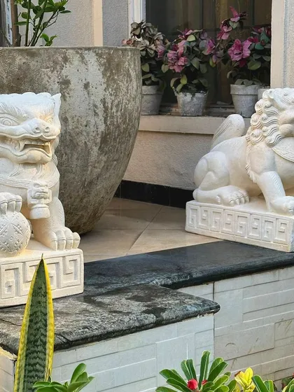 A pair of our sandstone Foo Lions standing guard at a client's home. Placing them as a pair, one on each side of an entrance, is the traditional way to display these protective statues.
