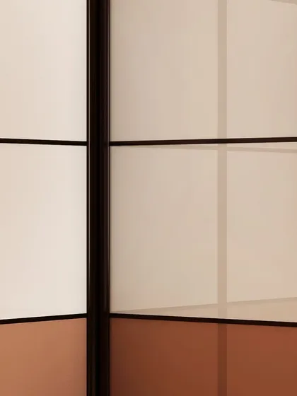 A detail of multi-panel wardrobe doors, combining different colors and finishes within a single frame for a customized, modern look.