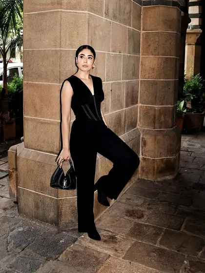 A full-length view of the black corseted jumpsuit, a perfect rental for a sophisticated evening event.