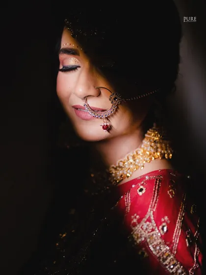A serene bridal portrait. With her eyes closed, this shot captures a moment of quiet contemplation and happiness, with soft light highlighting her makeup and nath.