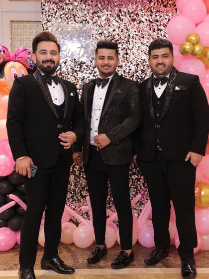 A group of friends all dressed in our custom black tuxedos for a party. We love outfitting the entire groom's crew.