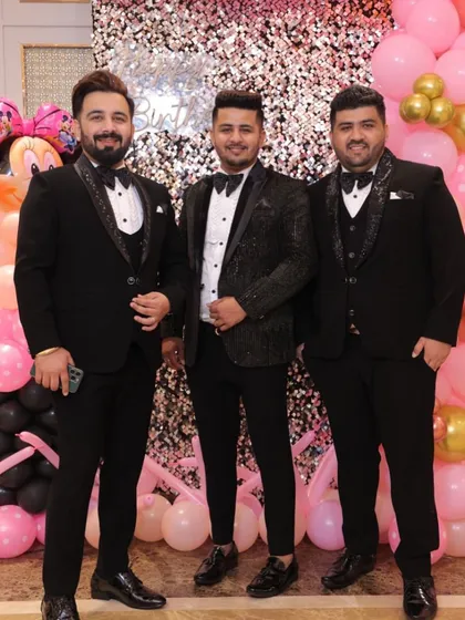 A group of friends all dressed in our custom black tuxedos for a party. We love outfitting the entire groom's crew.