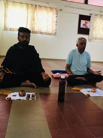 Two participants sitting in meditation after a practice session. The stillness that follows a Hatha Yoga practice is profound. Our space is designed to be a consecrated environment that supports this inward journey.