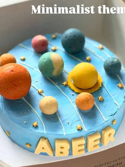 An out-of-this-world birthday cake for Abeer. This minimalist space theme features a solar system made of hand-molded chocolate planets on a beautiful blue whipped cream base.