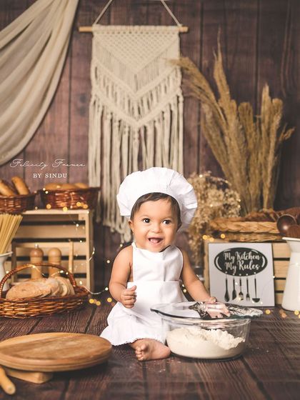 A happy little chef surrounded by all his baking supplies. The warm, rustic tones of this setup create a cozy and inviting atmosphere.