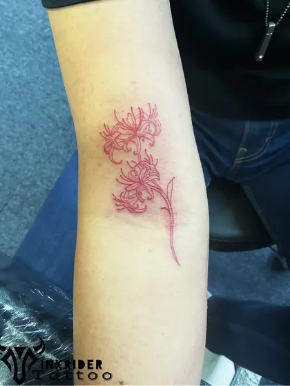 A red spider lily tattoo. This flower carries deep symbolic meaning in many cultures and its vibrant red ink makes for a striking design.
