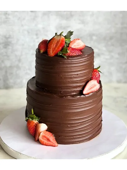 Embracing minimalist beauty with this two-tier strawberry chocolate cake. The clean lines of the chocolate frosting are perfectly complemented by fresh, juicy strawberries.