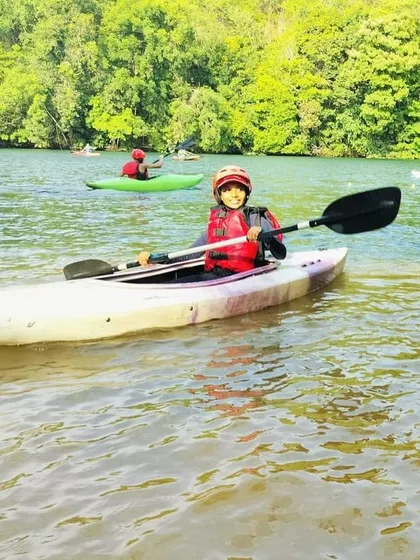 A happy camper enjoying a solo paddle during the Rafting and Kayaking Course at Dandeli.