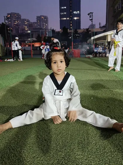 Flexibility is key in Taekwondo. Here, one of our youngest students, Anika, works on her splits, building the foundation for high, powerful kicks in the future.