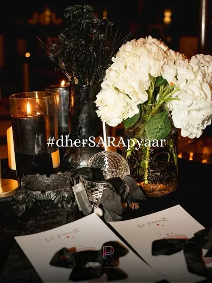The event hashtag, #dherSARApyaar, was incorporated into the decor. Here it sits next to a mini disco ball, custom stationery, and a mix of black and white florals.