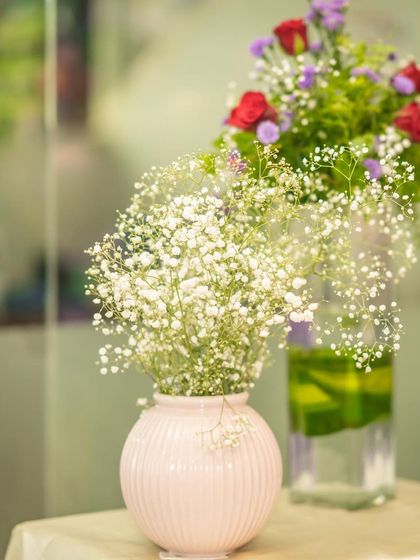 Fresh flowers in a simple vase can add so much life to a party. These delicate baby's breath and roses were part of the decor for a fairy-themed celebration, adding a touch of natural beauty.