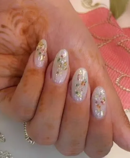 A delicate and shimmery set with a sheer white base and scattered flecks of colorful, dried-flower confetti.