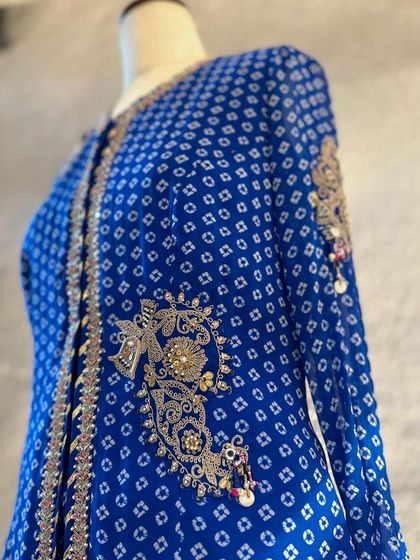 A detailed shot of a royal blue bandhani print kurta with exquisite embroidery on the side, showcasing fine craftsmanship.