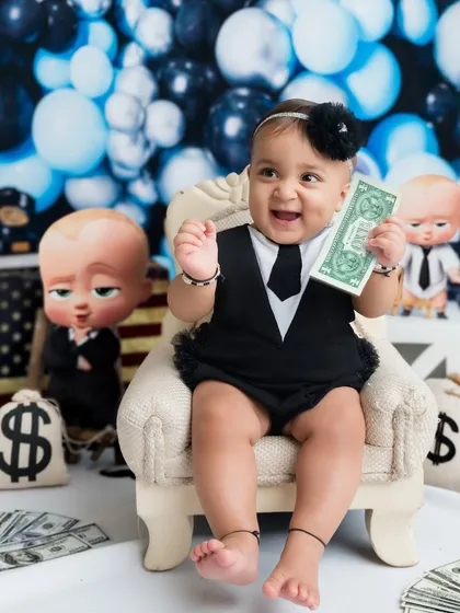 A huge, happy grin from the CEO of the house. The props and costume make this "Boss Baby" photoshoot so much fun.